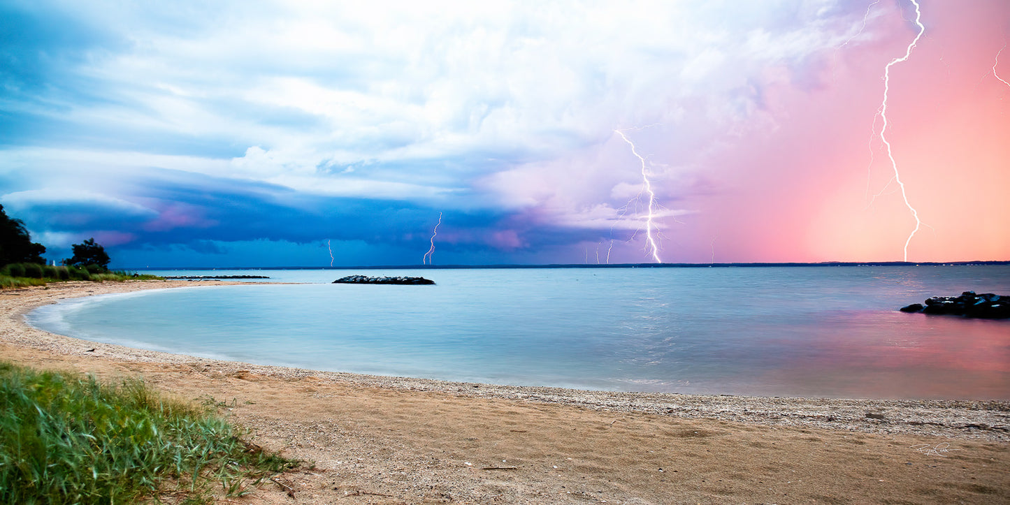 Celestial Fracture — A wide-angle view of a sandy Potomac River beach at dusk, featuring multiple vivid lightning bolts striking the horizon under a gradient sky of deep blue and sunset pink.